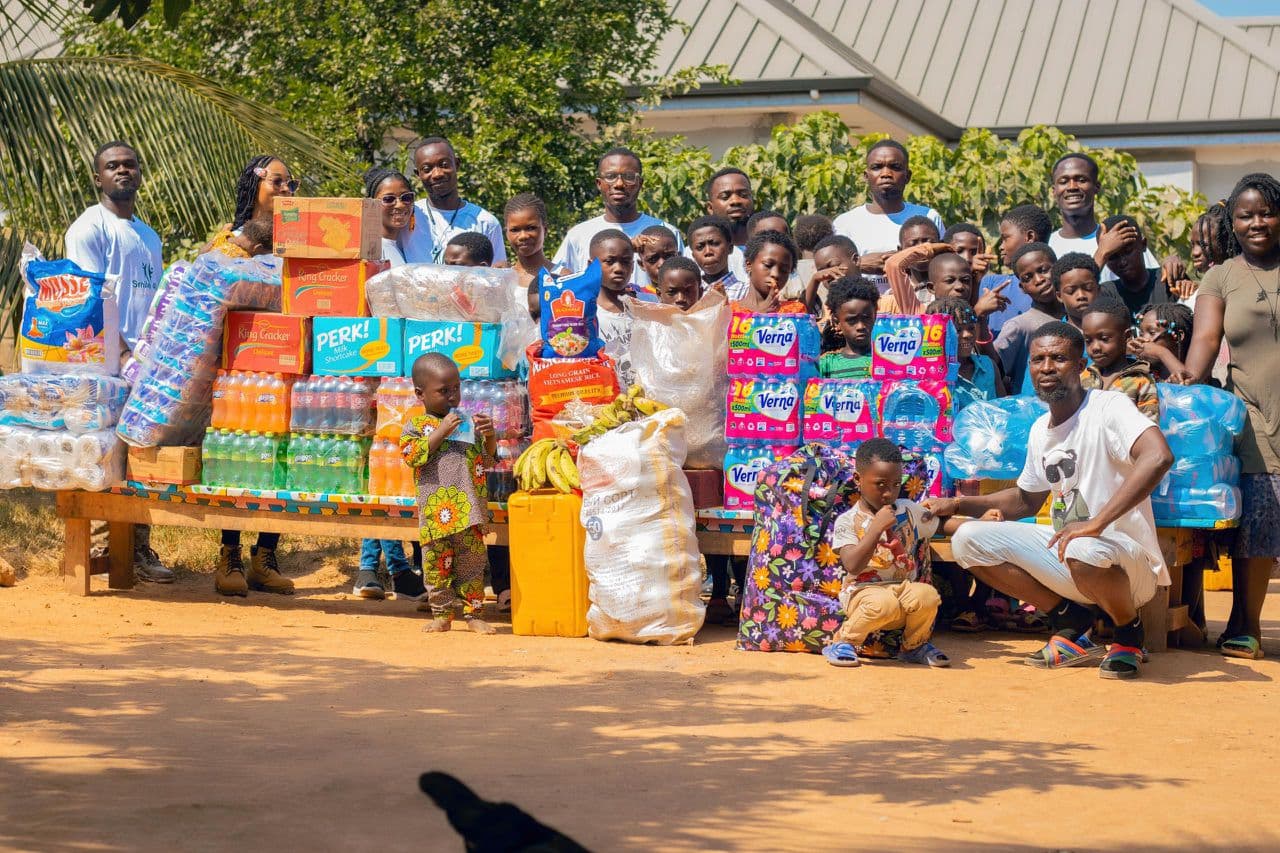 Community donation items arranged with volunteers and children.